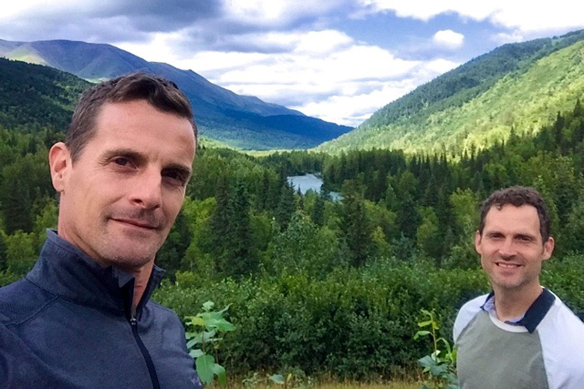 MSK patient Mark McIntosh and his husband, Edgar, posing in front of grassy mountains
