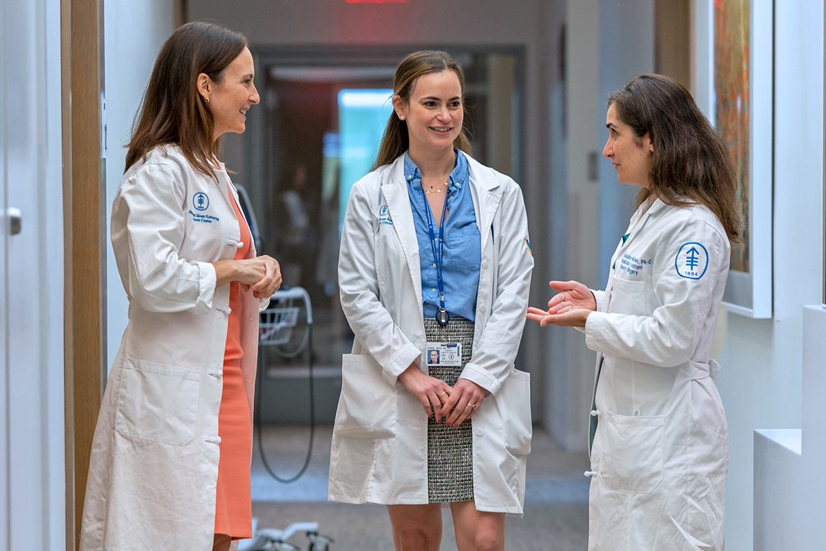 乳腺癌外科医生 Stephanie Downs-Canner 博士、护士 Skylar Parr 和医生助理 Luisa Godoy-Rosales 在走廊中