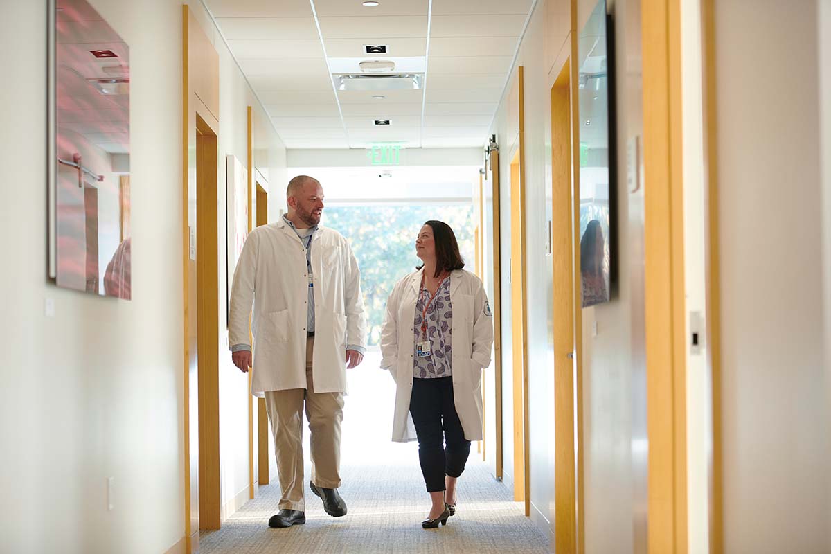 El enfermero Bryon Wanderer y la enfermera practicante Erin Scansarole caminando por el pasillo