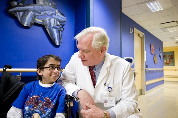 Richard O'Reilly, Chair of the Department of Pediatrics and Chief of the Pediatric Bone Marrow Transplant Service, stops to chat with a patient in the hallway.