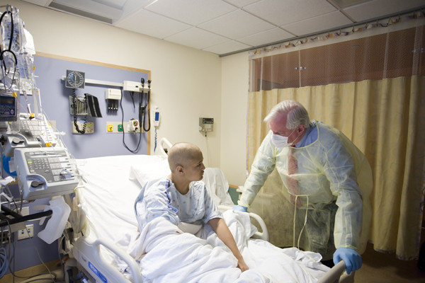 Richard O'Reilly, Chair of the Department of Pediatrics, visits a young patient in isolation.