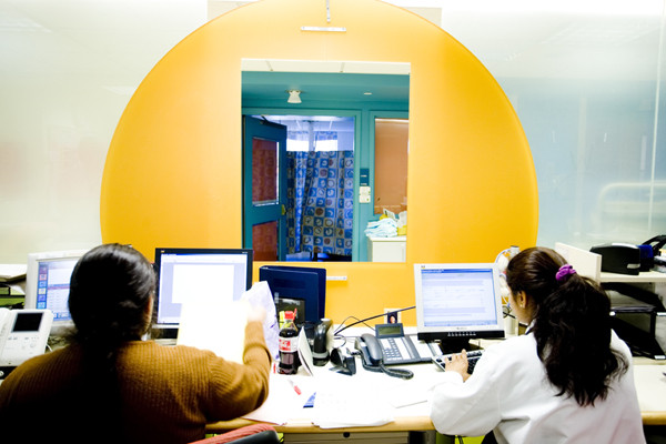 The nursing station's brightly colored window is open to allow easy communication between medical staff and families.