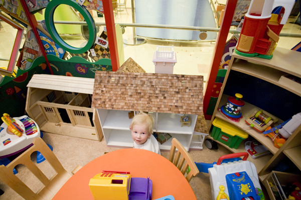 A young patient checks out a favorite doll house within our play center: The Monopoly House.