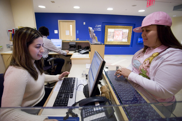 A session assistant checks in a patient for her appointment in the Pediatric Day Hospital.