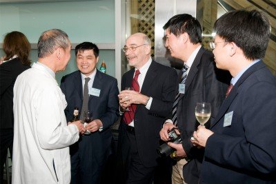 Physicians from Fudan University at a reception held in their honor speak with Memorial Sloan-Kettering medical physicist Clifton Ling (white jacket) and Robert Wittes (red tie).