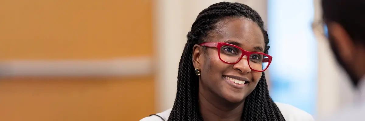A clinical trials nurse smiles as she talks with an MSK colleague. 