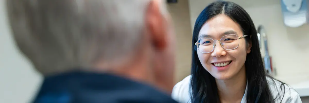 An MSK nurse practitioner who works with people who have head and neck cancers talks with a patient. 