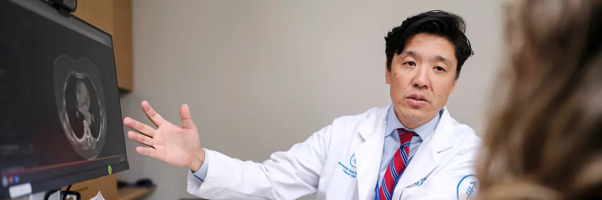 Head and neck medical oncologist Dr. Alan L. Ho, Chief of MSK’s Head and Neck Oncology Service, points to a scan image on a computer monitor as he talks with his patient.  