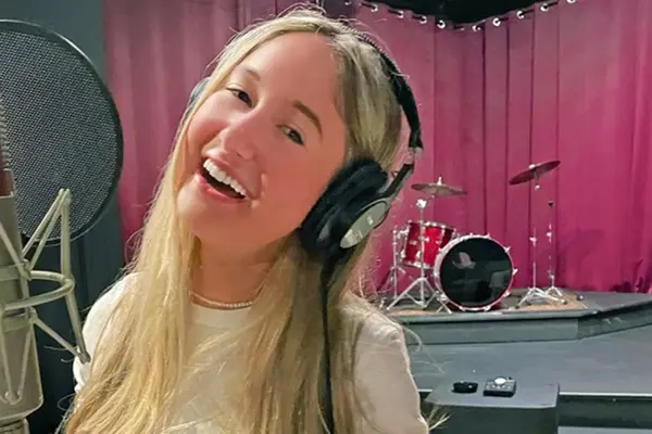 Thyroid cancer survivor Annabel Gutherz, treated for cancer at MSK, is singing in front of a microphone in a recording studio.   
