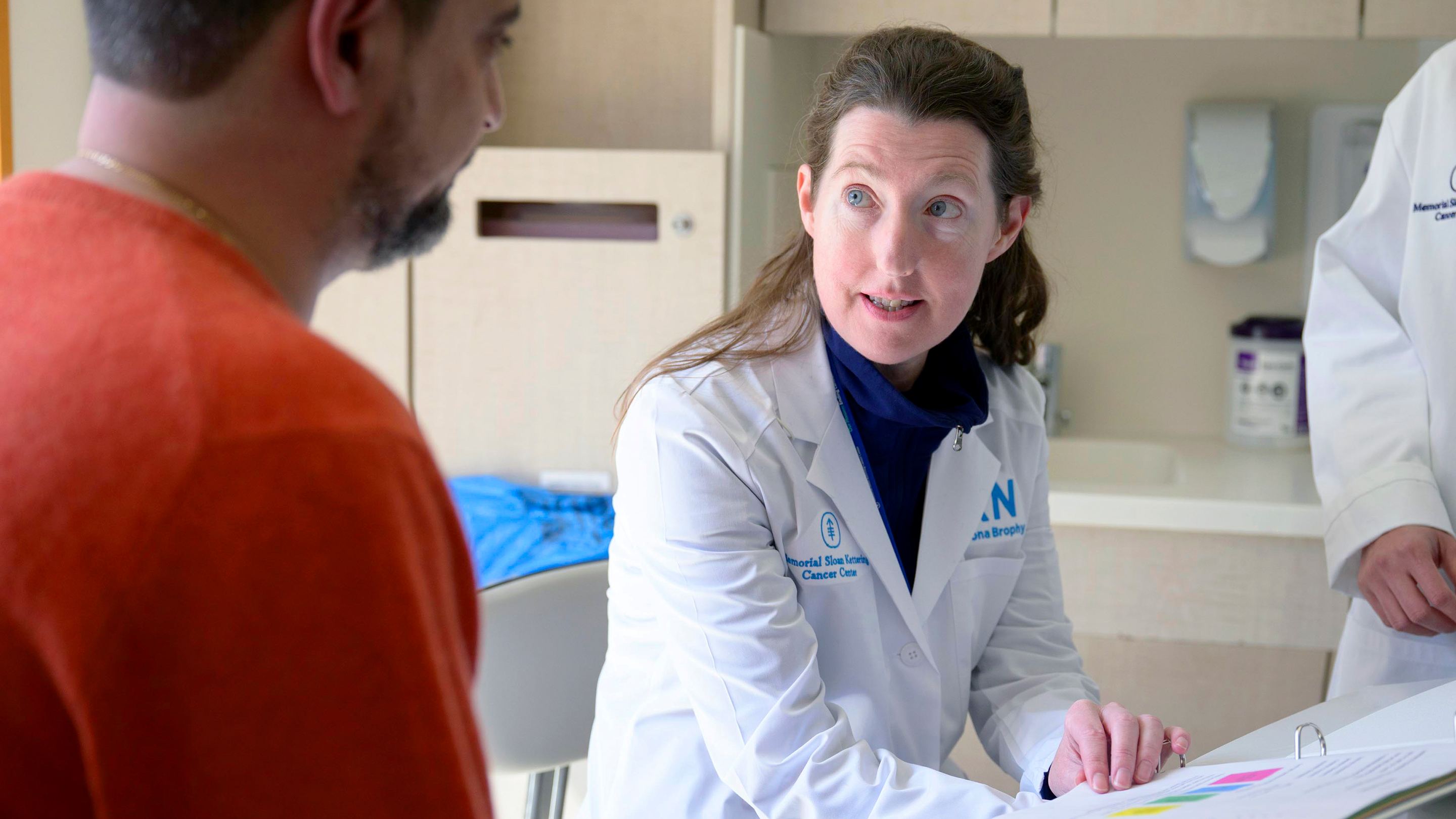 Registered nurse Leona Brophy is in an MSK exam room talking with her patient. 
