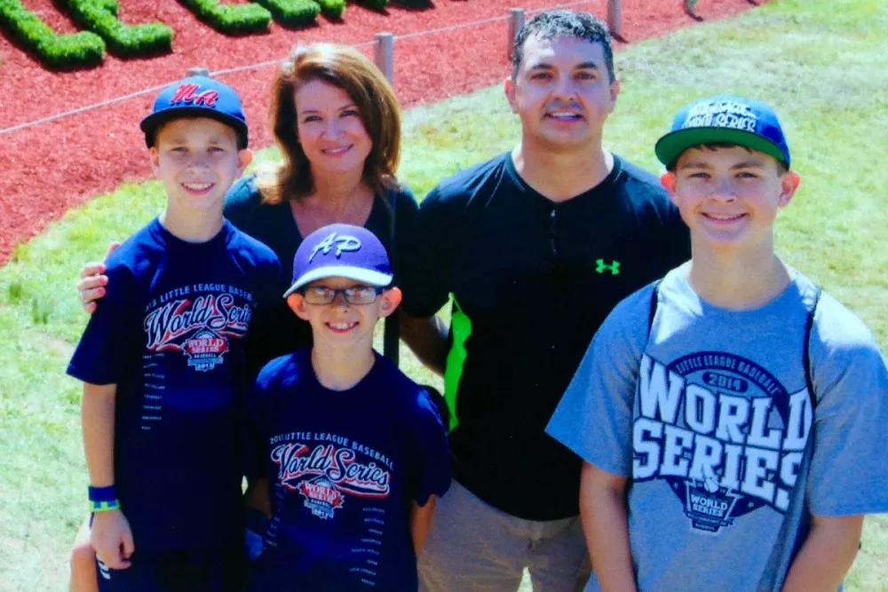 Man standing with wife and 3 sons at Little Leage World Series