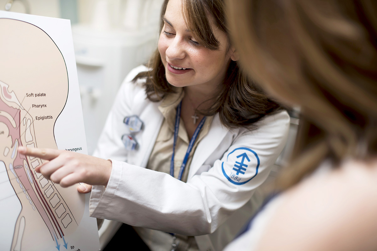 Speech pathologist, Katherine Kougentakis, from the MSK Head and Neck Cancer Care Team pointing to a diagram of a neck.