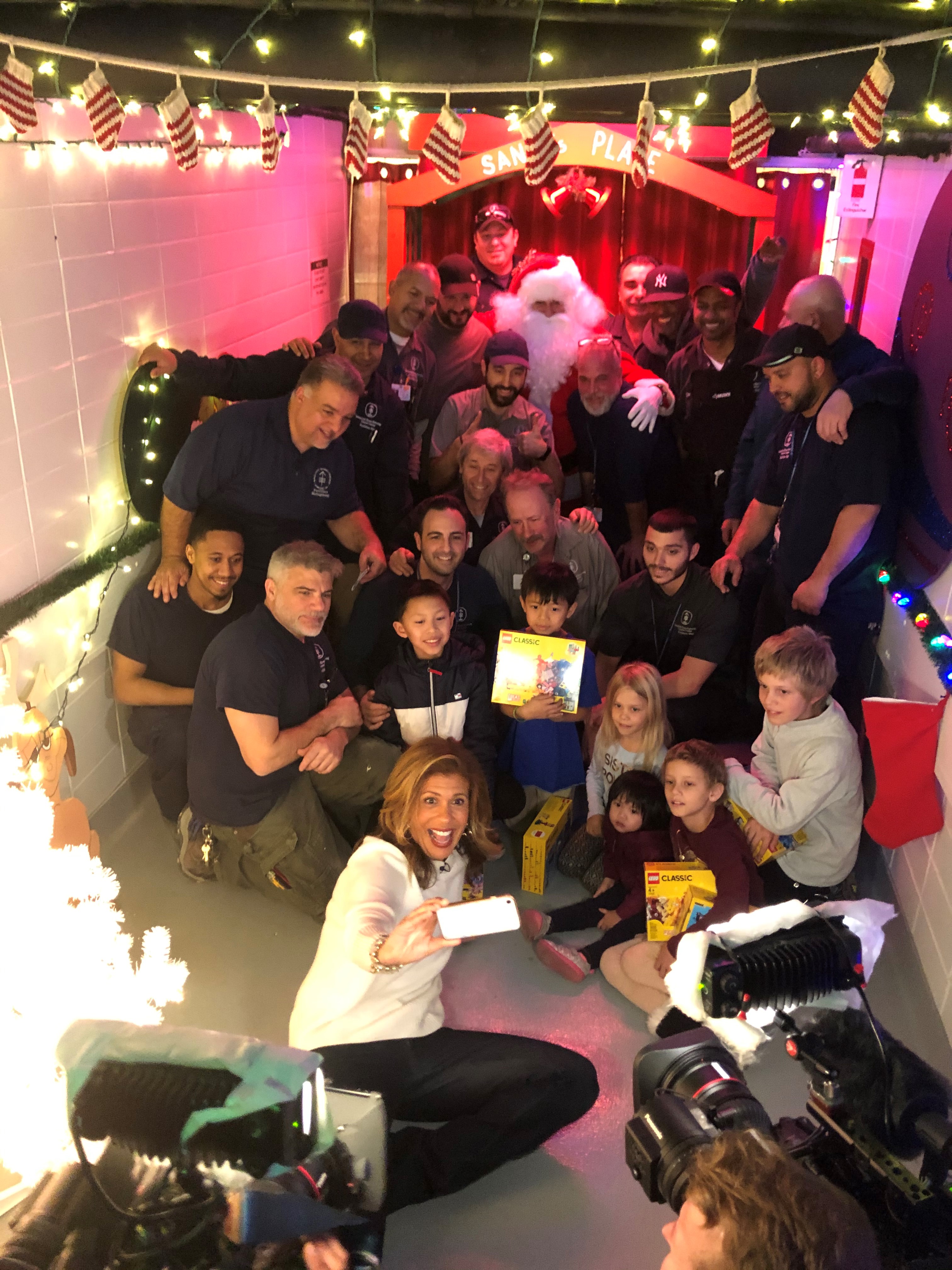Today Show host, Hoda Kotb, takes a selfie with MSK’s Department of Facilities in MSK’s Holiday Hallway