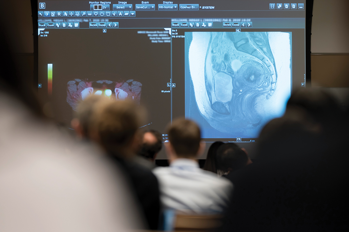A group looks at a radiology image on a large screen