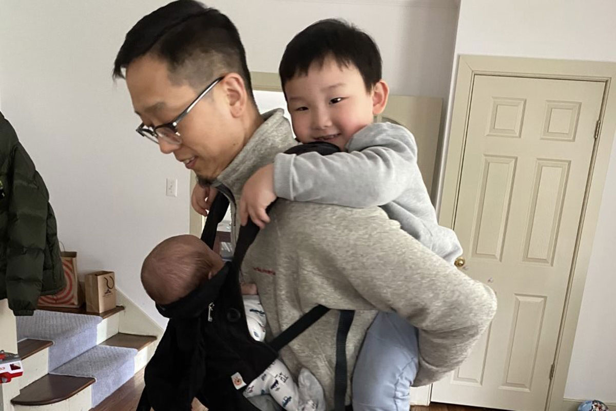Paul Yoon holding two young boys