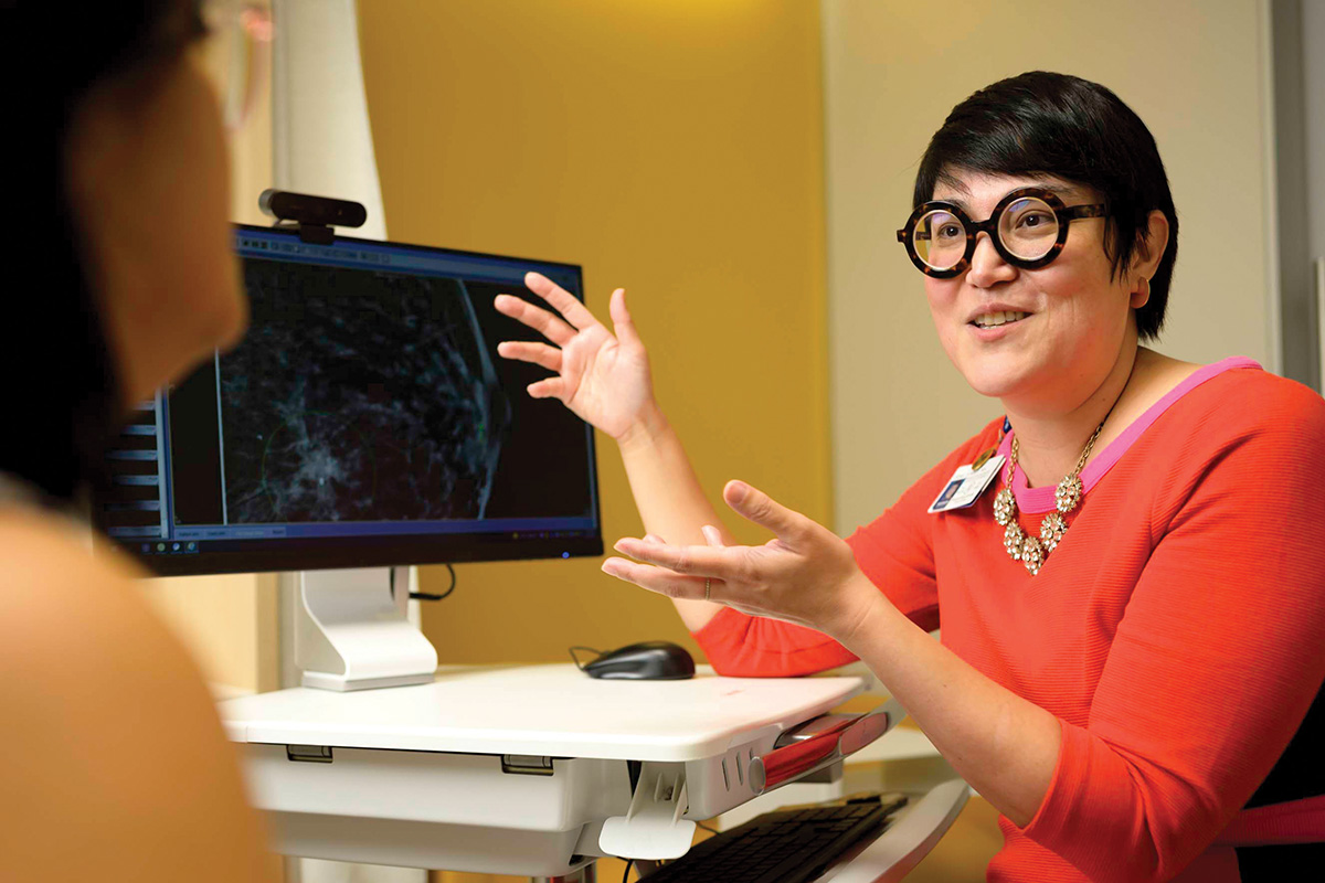 MSK radiation oncologist Fumiko Chino gesturing at a computer