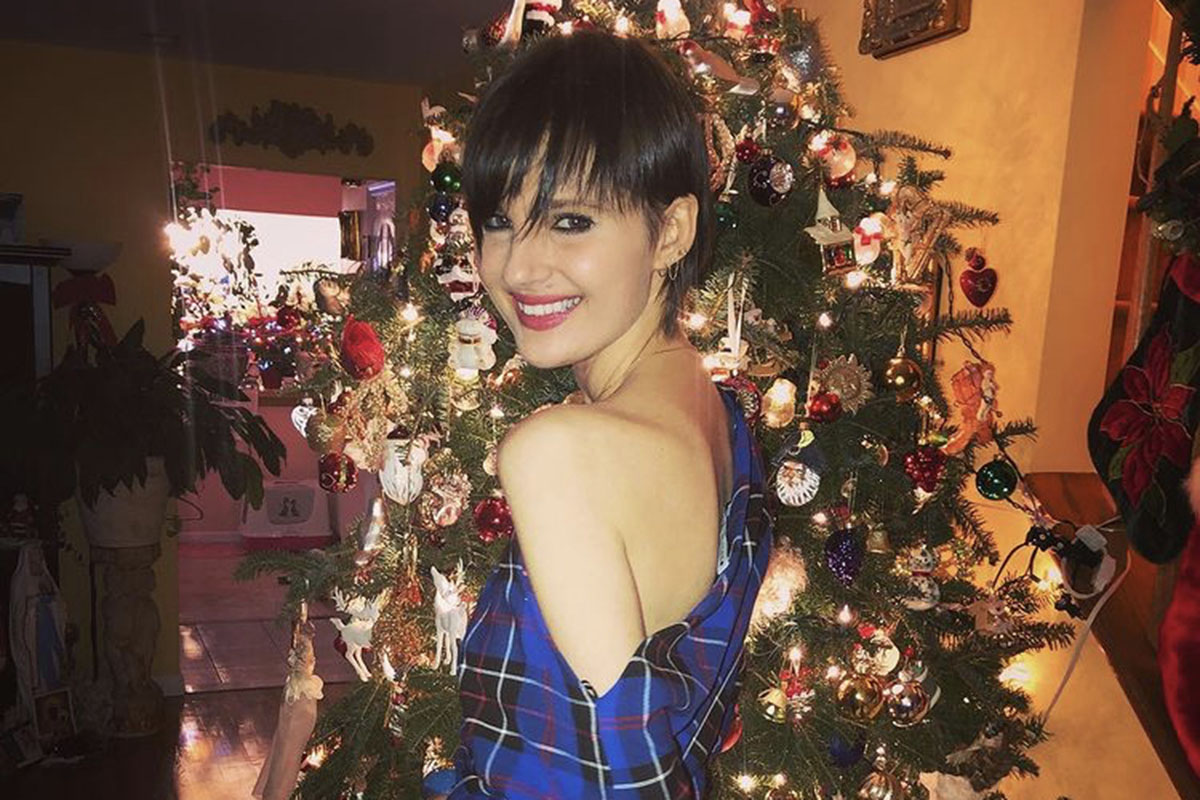 Eliza posing in front of a Christmas tree
