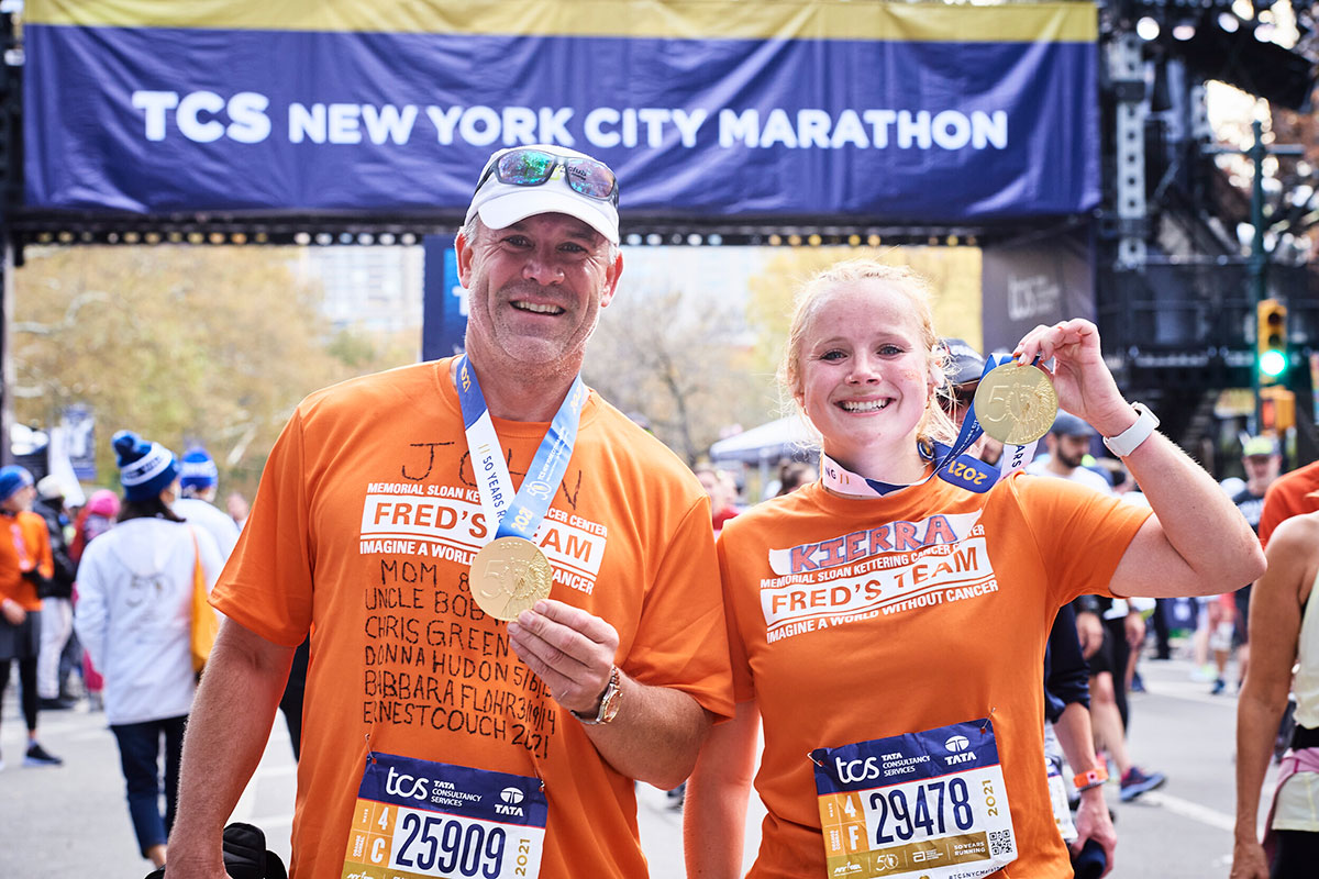 Two runners posing with their medals at the finish of the TCS New York City Marathon