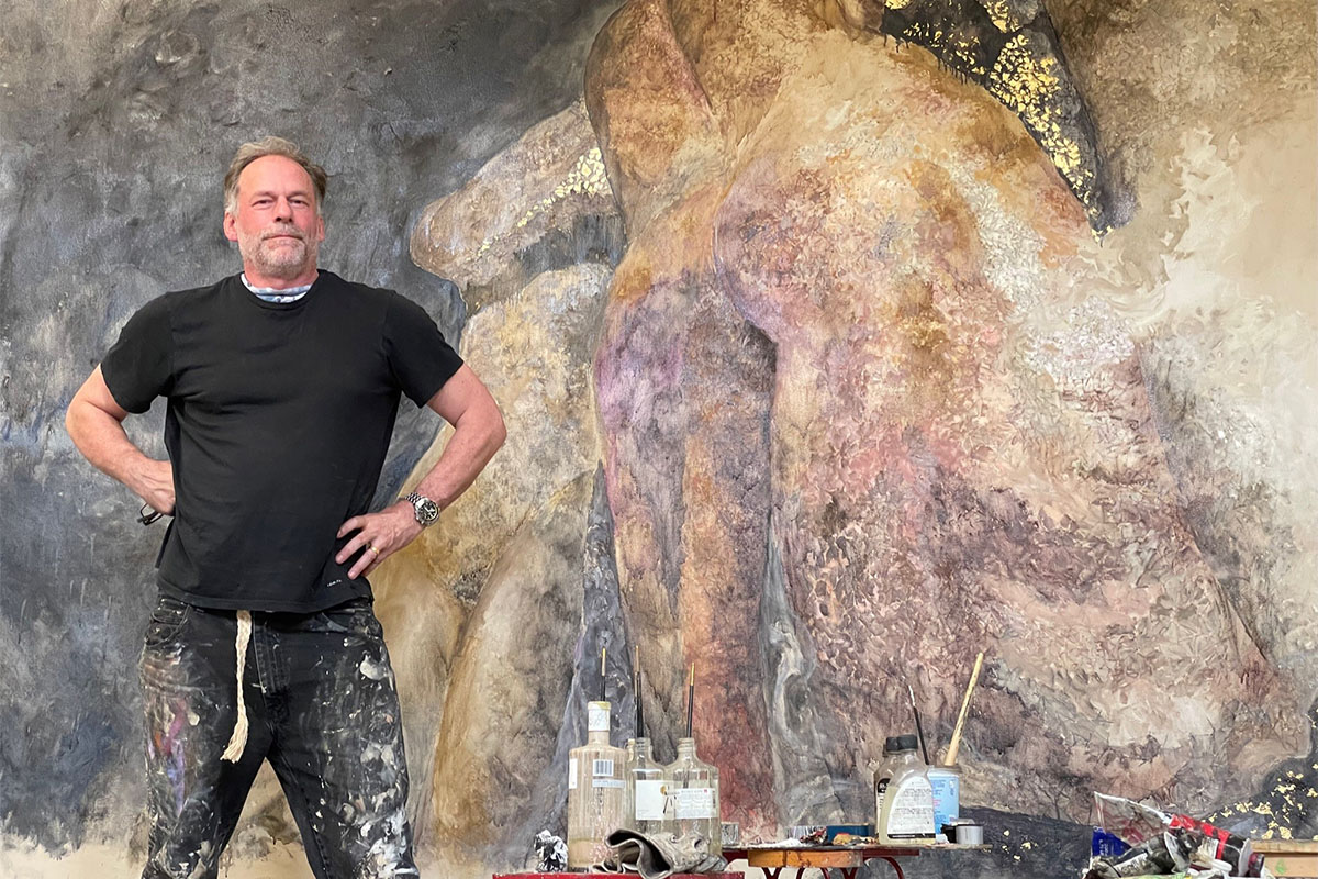 Man standing next to large modern painting 