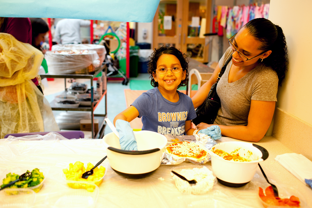 A patient and her mother prepare pizza during cooking group.