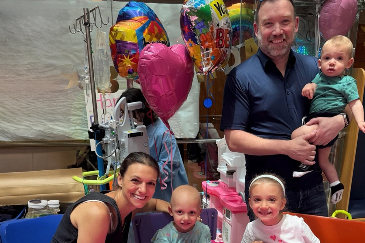 Sienna and her family with balloons and a birthday cake