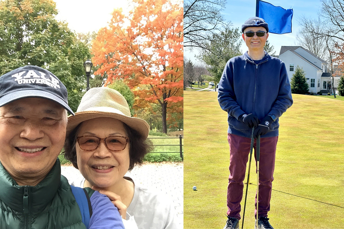 Elderly Asian couple smiling and standing alone on golf course smiling.