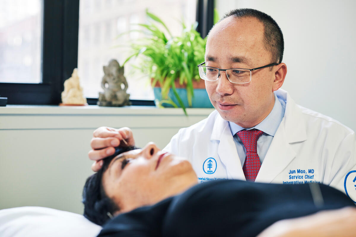 Dr. Jun Mao performs acupuncture on a patient.