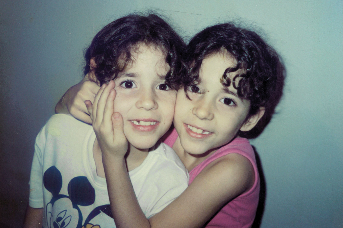 Two young sisters hugging and smiling
