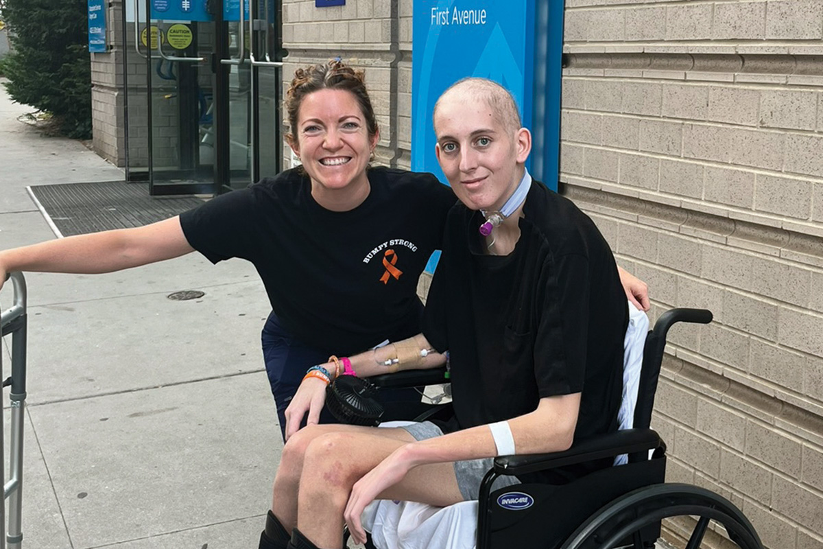 Nurse Chelsea Lubischer outside MSK Kids with Tommy in a wheelchair