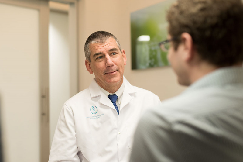 Smiling physician speaking with patient.