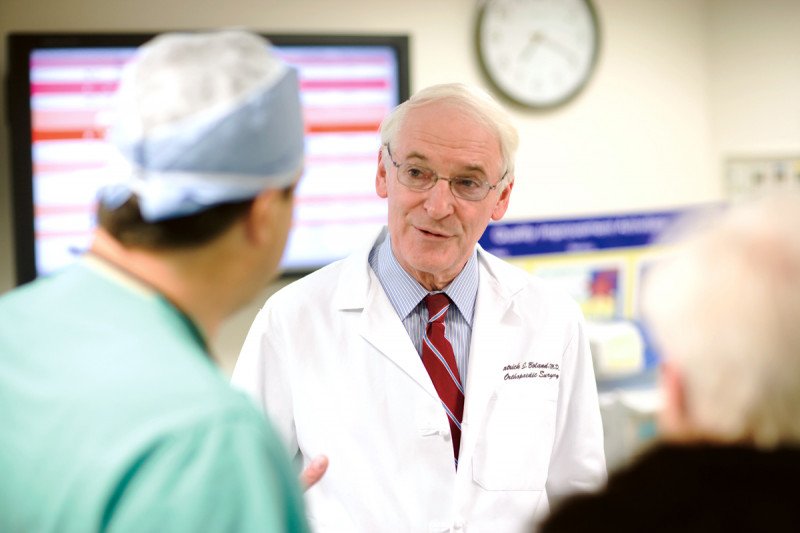 MSK orthopedic surgeon, Patrick Boland, speaks with a male colleague who is dressed in scrubs.