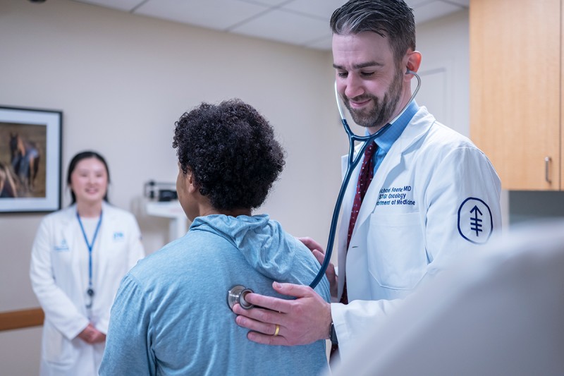 Dr. Foote is examining his patient with a stethoscope in an MSK exam room.
