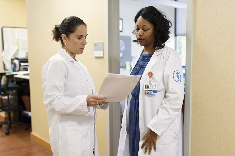 MSK Nassau medical oncologist, Zoe Goldberg, analyzes papers with fellow colleague.