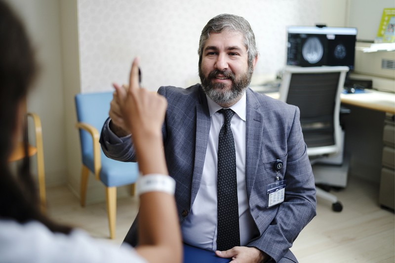 Pediatric neurosurgeon Andrew Joshua Kobets, MD, MHS, talks to an MSK Kids patient. 