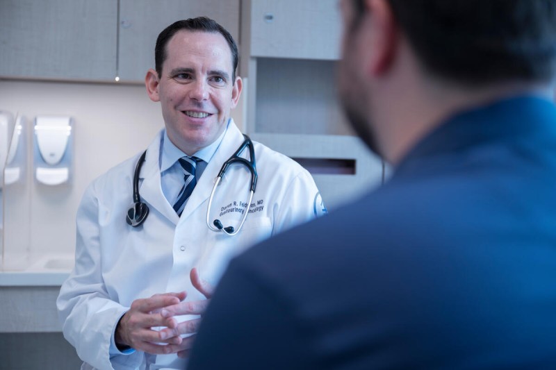 Doctor in white coat talking to a patient.