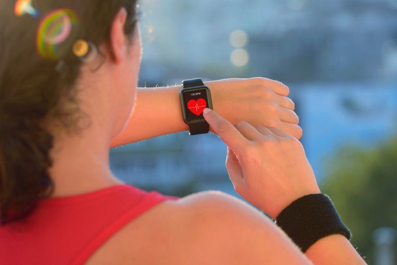 A woman who is exercising checks her heart rate.