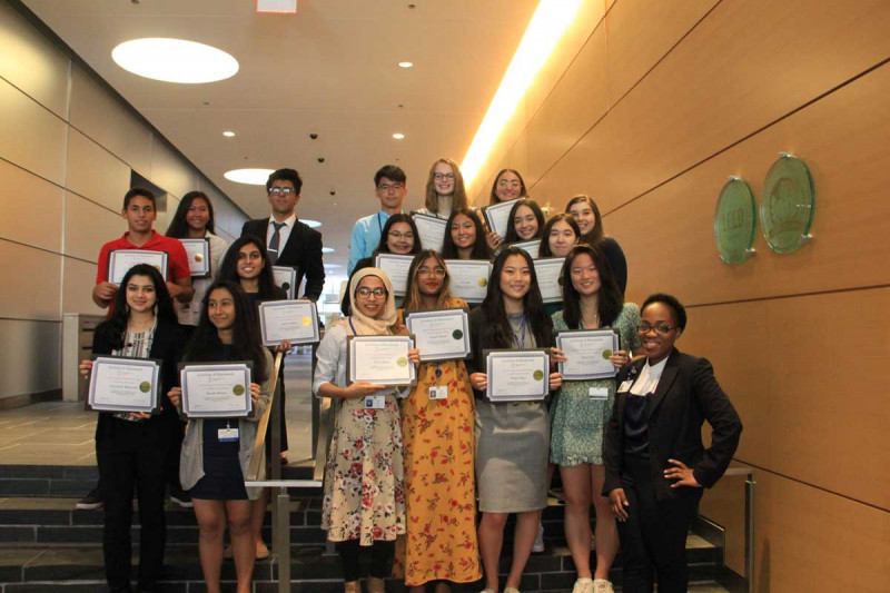 HOPP SSP Program Manager Vicky Baudin poses with some 2019 students after their poster session