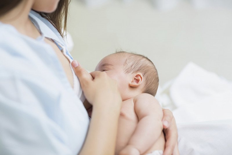 A mother being treated for cancer breast-feeds her baby.