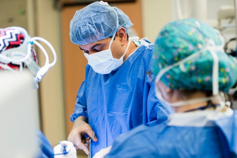 Surgeon in blue scrubs doing operation with two assisting.