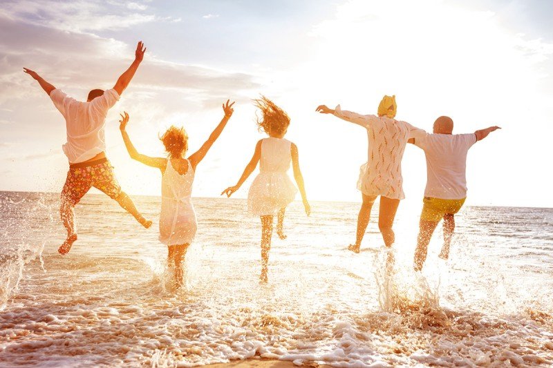 Five people on the beach during a sunset