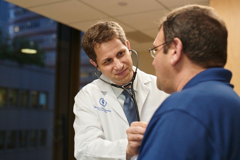Medical oncologist Bill Tap examines a patient