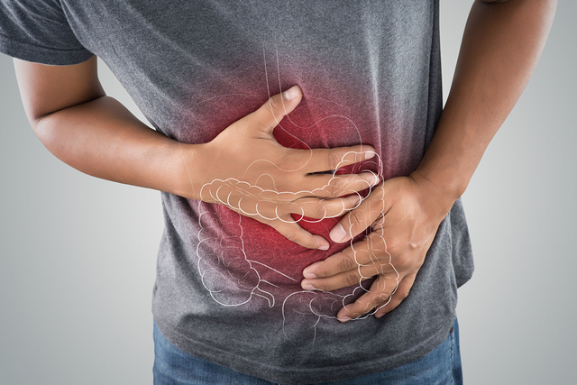 A man clutches his stomach in pain