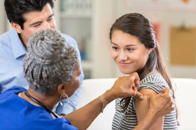 Nurse bandaging patient after vaccination