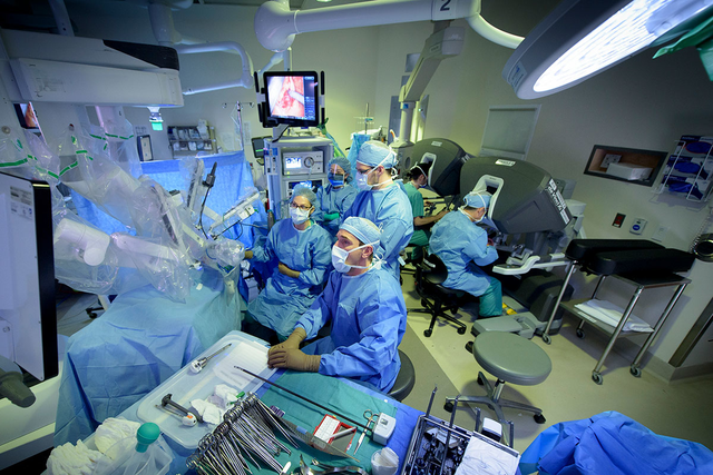 MSK surgeons gathered around a robot used for cancer surgery