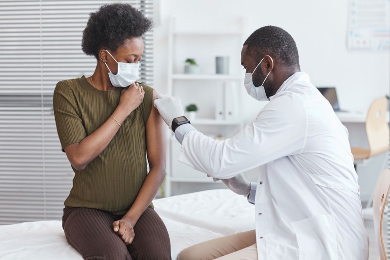 woman getting vaccine from doctor