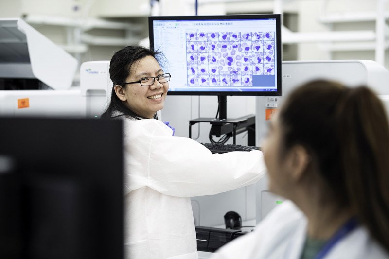 Una especialista le sonríe a su colega en el laboratorio de respuesta rápida, diseñado para brindar una atención más rápida y más conveniente para los pacientes.