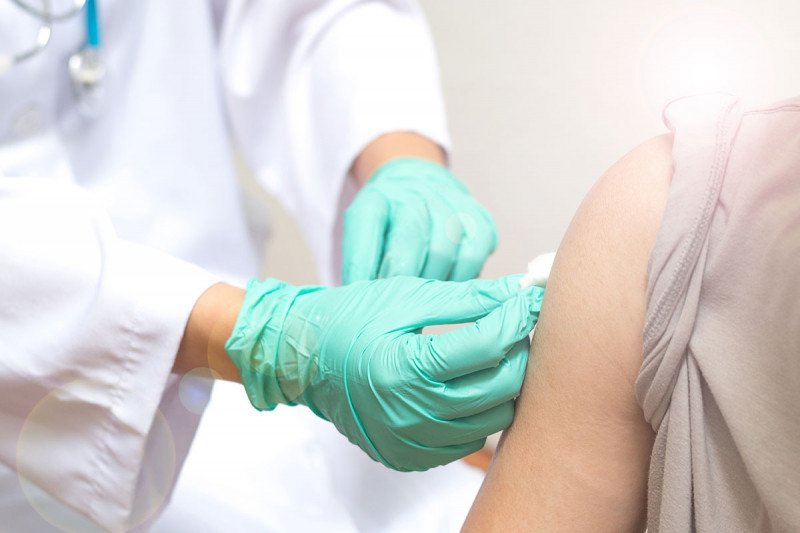 Doctor rubbing down patient's arm with alcohol swab