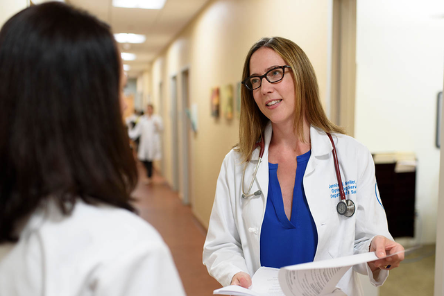 MSK surgeon Jennifer Mueller holding files while speaking to fellow doctor.