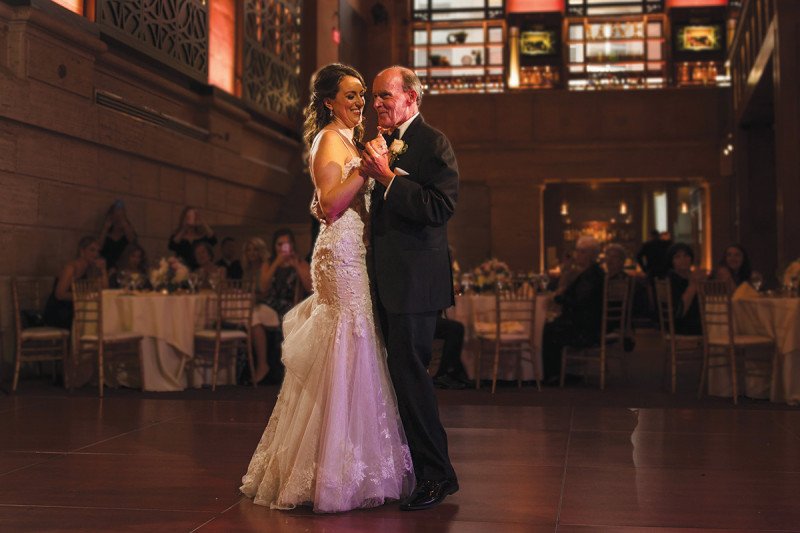 A man and woman dance at a wedding reception