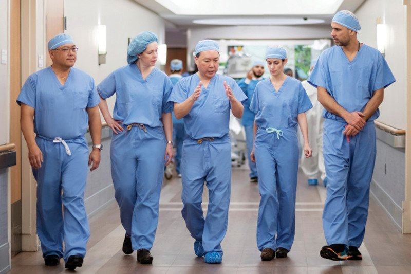 Five surgeons walk down a hallway